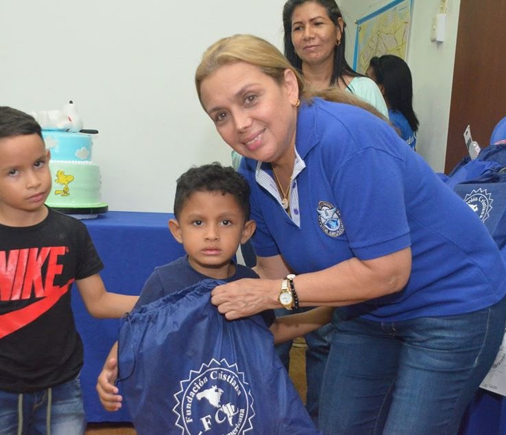 Reresentante de la fundacion entegrando ayuda a niño