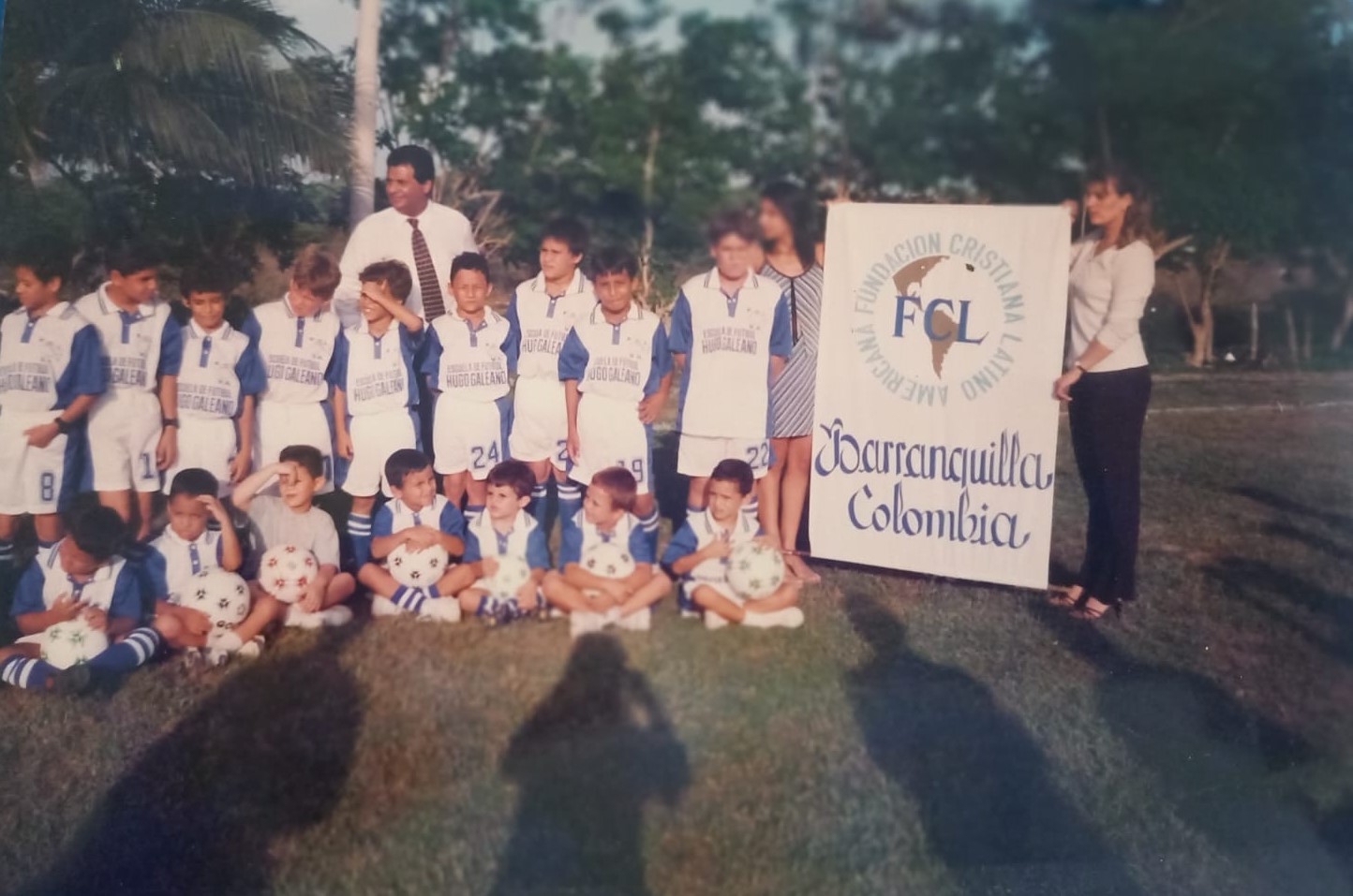 Equipo de futbol de niños con pancarte de la fundacion